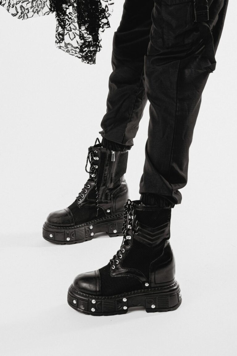 Close-up of stylish black platform boots and lace detail in a studio.